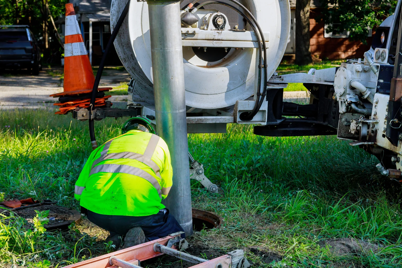 Vacuum truck removing waste material from a holding structure