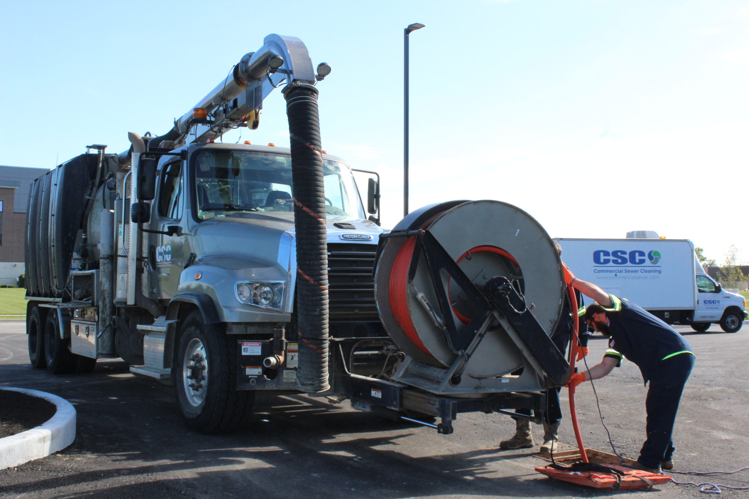 Sewer cleaning crew working with equipment on a commercial sewer line