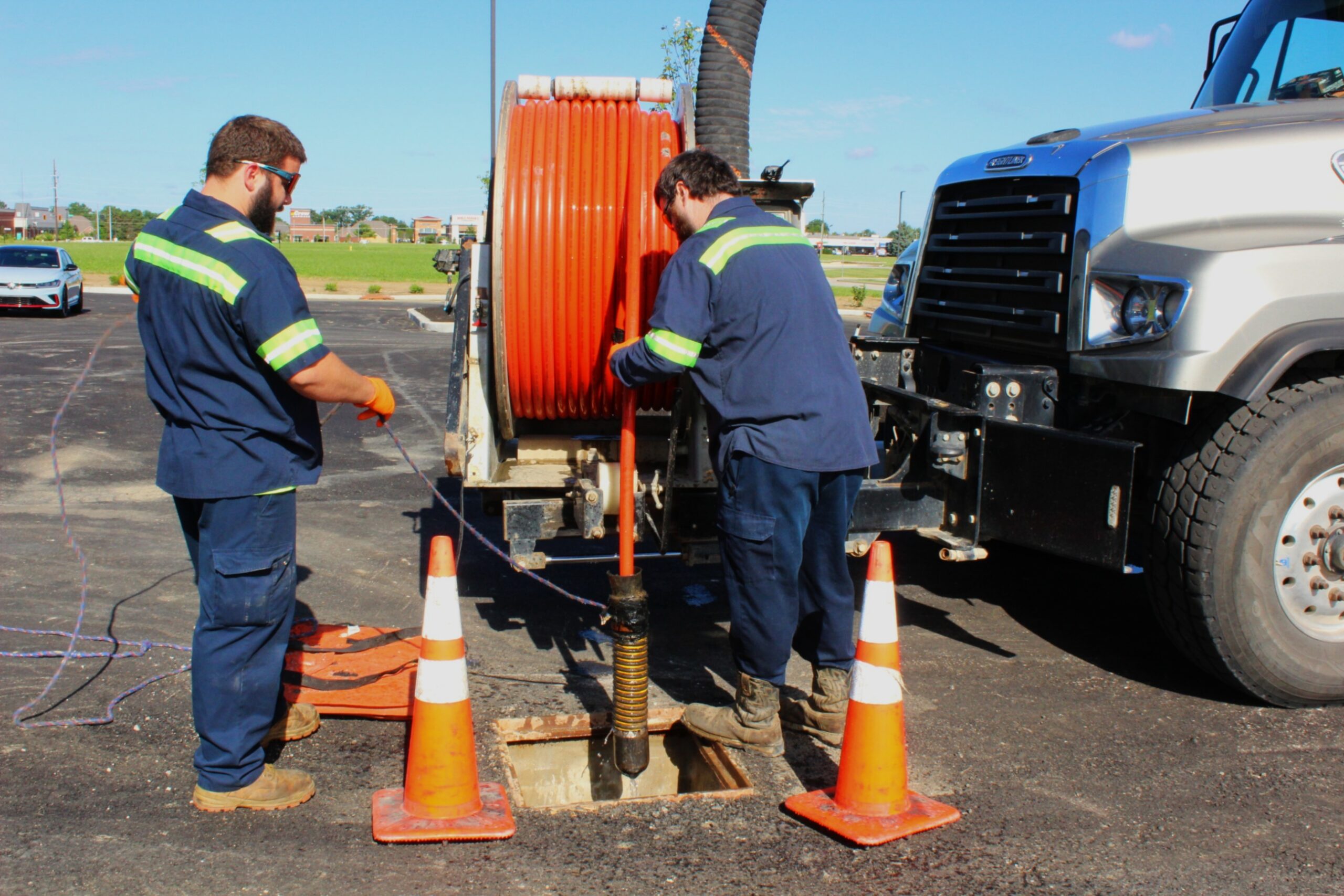 Worker inspecting underground pipe systems