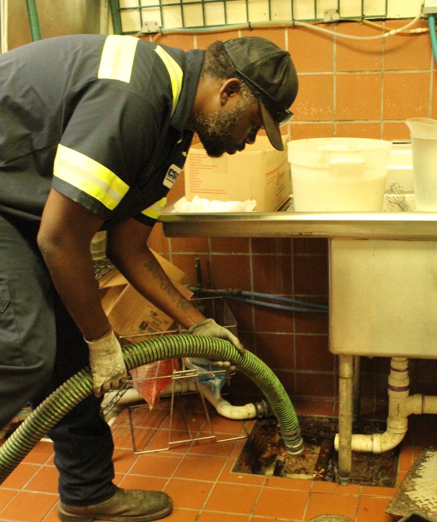 Sewer cleaning crew with equipment servicing a commercial grease system