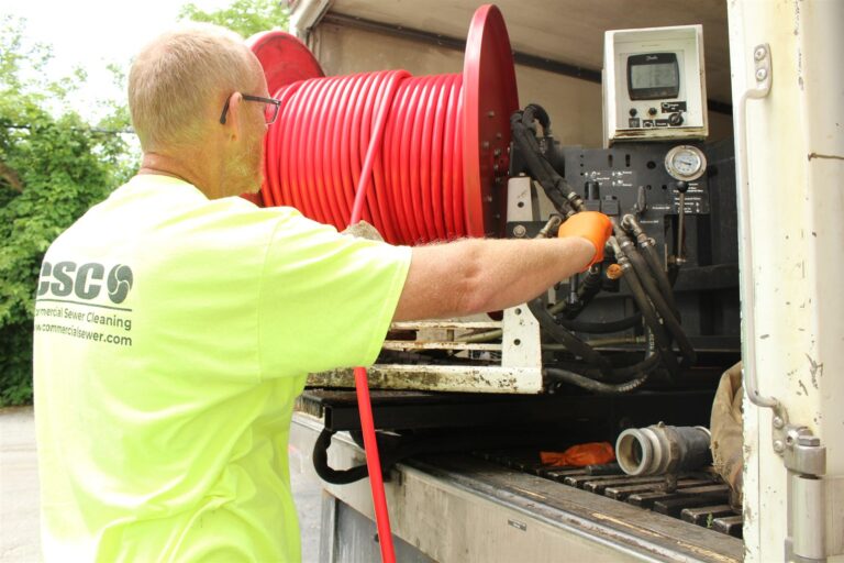 Difference between snaking and hydro jetting a drain: a CSC technician at the controls of a truck-mounted hydro jetter reel